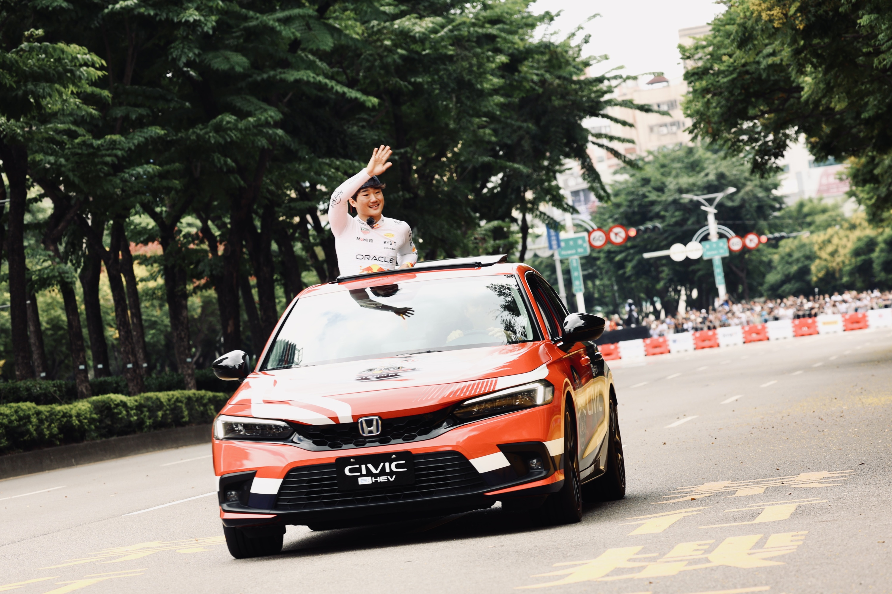 F1日籍賽車手角田裕毅乘車遊行賽道一圈，與夾道爆滿的六萬名觀眾的熱烈互動。（Red Bull 提供）.jpg