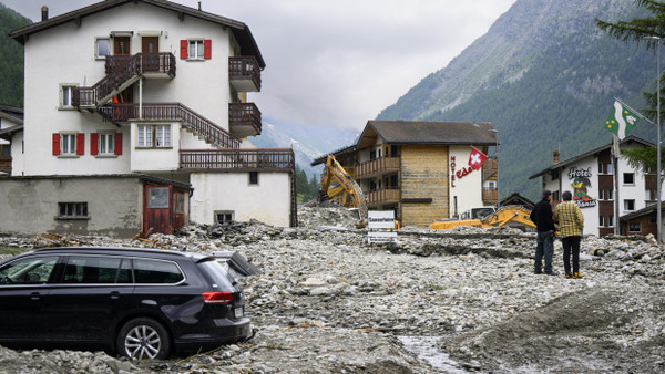 Nach einem Erdrutsch in Saas-Grund begutachten Bewohner am Montag den Schaden.