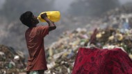 Durstig: Ein Arbeiter ist während einer Hitzewelle Mitte Juni auf einer Mülldeponie in Jammu, Indien, im Einsatz.