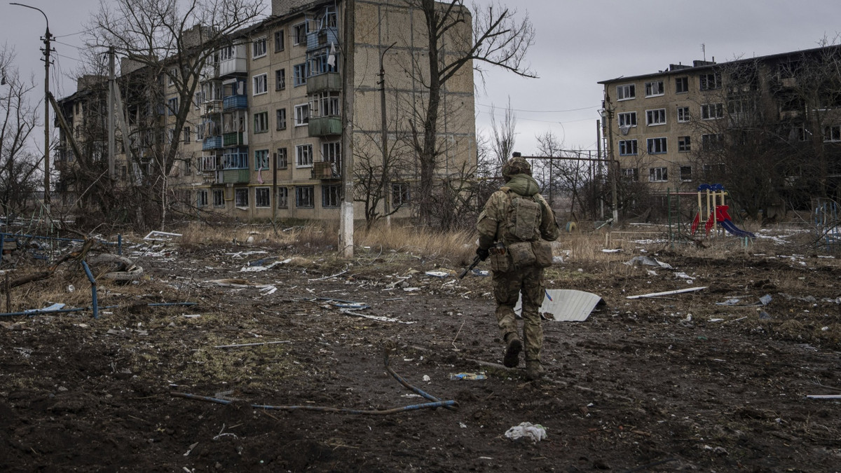 Als Wuhledar noch in ukrainischer Hand war: Ein Soldat rennt im Februar 2023 an beschädigten Häuserblocks vorbei