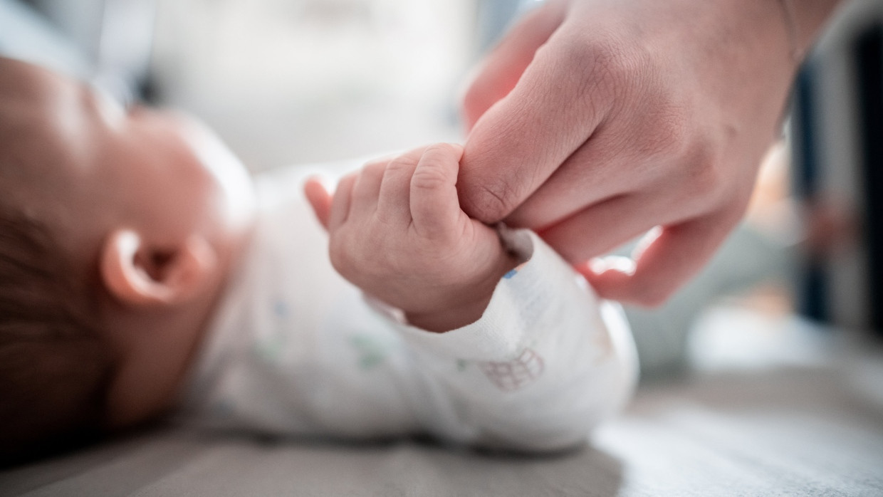 Ein Baby hält den Finger seiner Mutter. (Symbolbild)