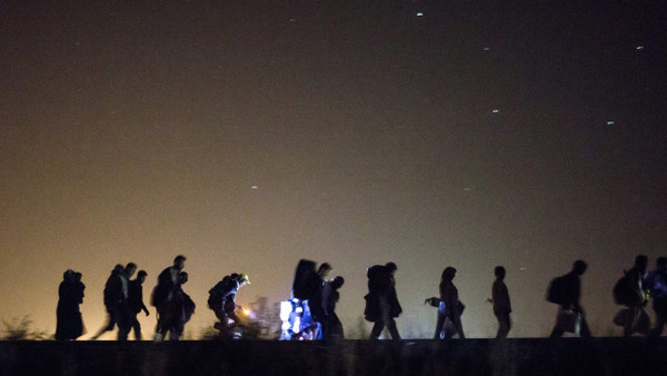 Flüchtlinge gehen im Herbst 2015 nachts über Bahnschienen auf einen Checkpoint bei Röszke, Ungarn, zu.