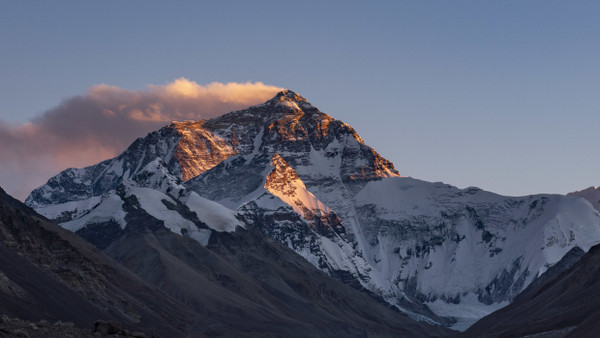 Der Sonnenuntergang färbt den Gipfel des Mount Everest.