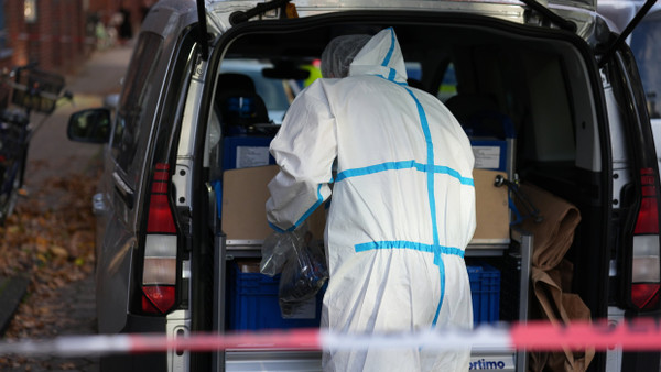 Ein Mitarbeiter der Kriminaltechnik vor dem Mehrfamilienhaus, in dem ein Mann erschossen wurde