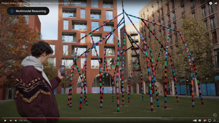 Man befragt das Handy mündlich: „Was ist das für eine Skulptur?“ Die Maschine blickt auf das Kunstwerk und identifiziert es als „My World and Your World“ von Eva Rothschild. Die KI spricht. Das Video dazu ist im Text zu sehen.