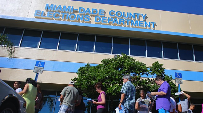 A small group of residents stand outside a county elections building