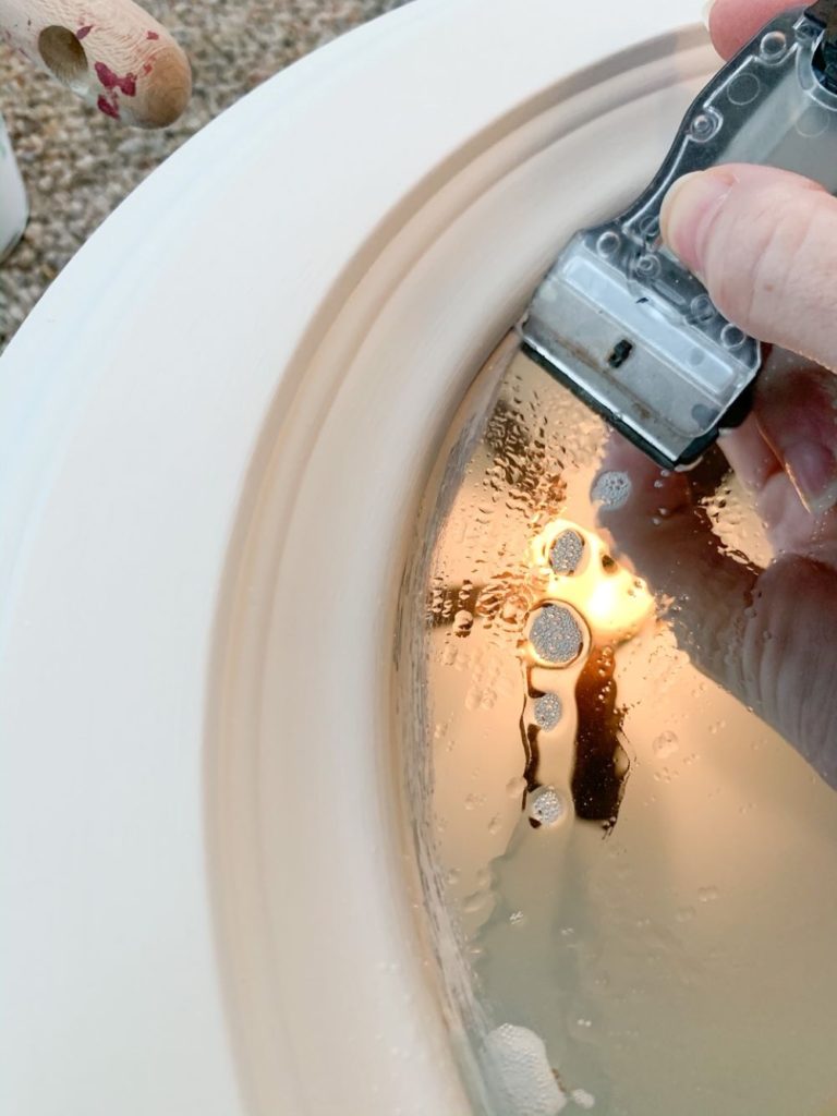 With glass cleaner on the mirror and using a razor, the excess paint on the painted mirror will come right off and wont scratch your mirror