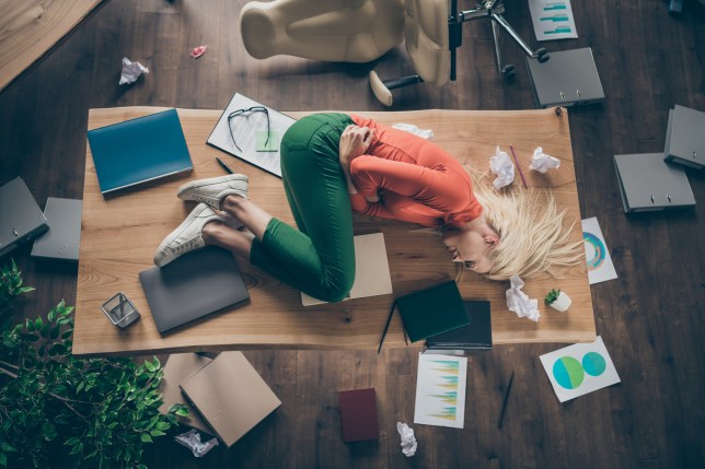 High angle above view photo of corporate messy atmosphere unorganized blond business lady lying table suffering period pms holding hurt belly wear casual outfit indoors