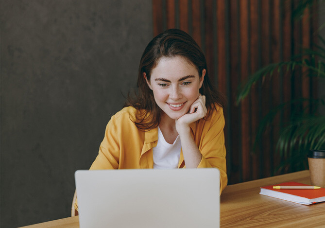 Imagem de uma mulher em frente a um notebook pesquisando como entrar em contato com o Mercado Pago para ter atendimento especializado sobre abertura de conta e solicitação de cartão de crédito Mercado Pago sem anuidade.