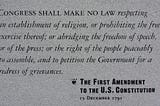 A photograph of a stone plaque engraved with the First Amendment to the United States Constitution