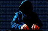 An image of a hooded hacker, who is typing on a keyboard in front of a background made of a binary code