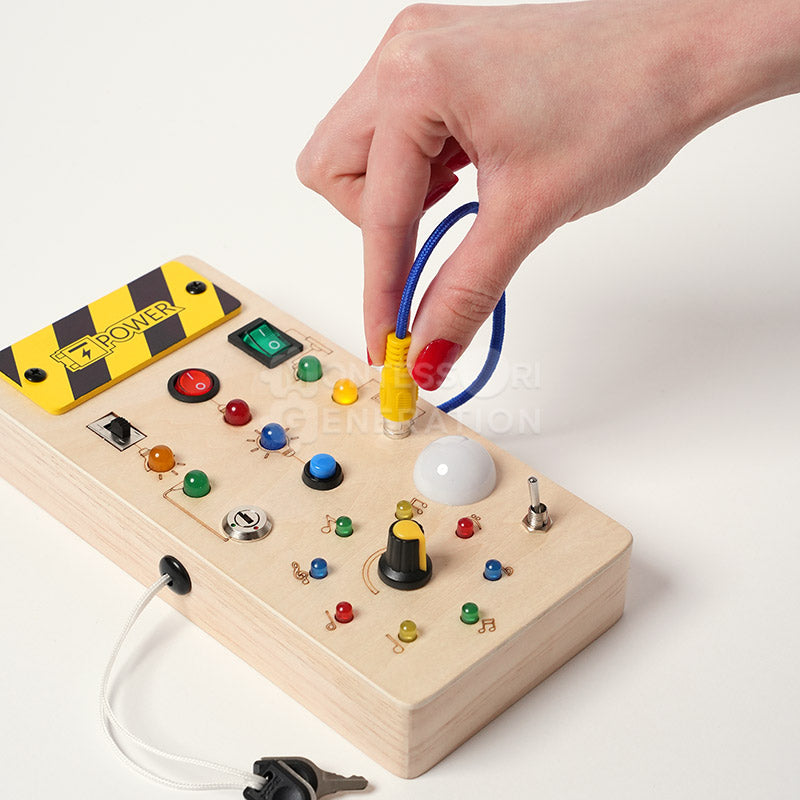 Hand interacting with a yellow plug on the Montessori Wooden Switch Board.