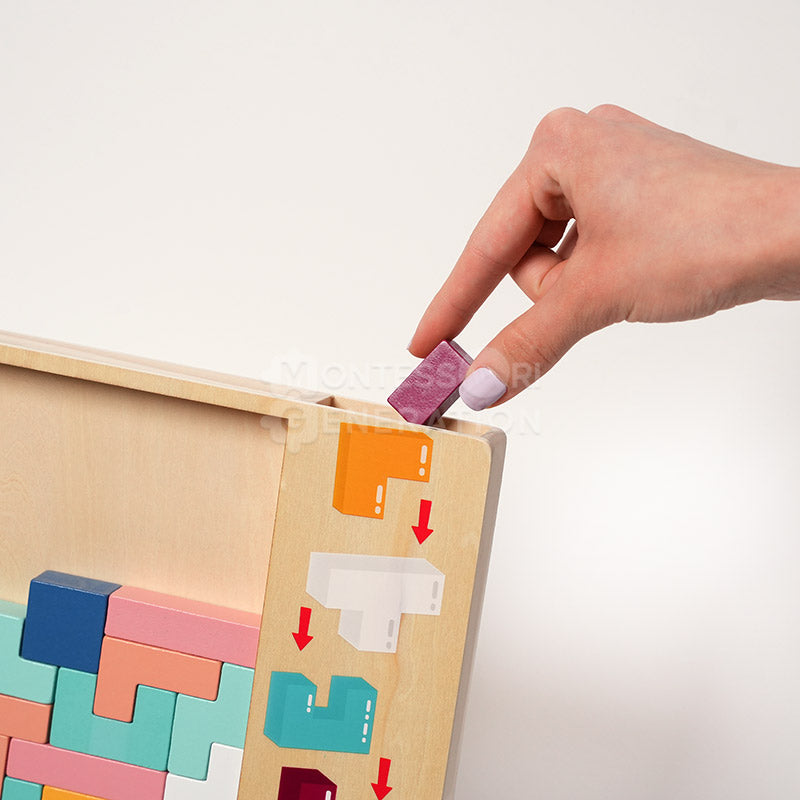 A hand interacting with the Montessori Wooden Tetris by inserting a colorful piece down the chute on the board.