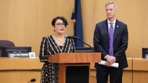 Jessica Vega Pederson stands at a dais next to Mayor Ted Wheeler