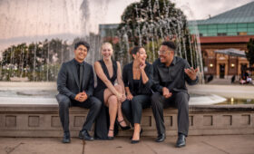 USC Thornton singers seated at campus fountain, talking.