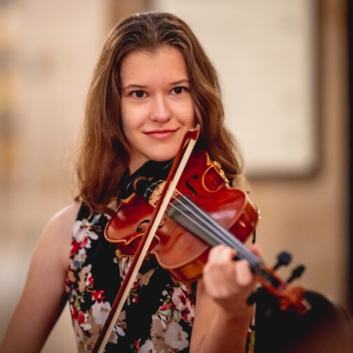 USC Thornton student playing the violin, seated.