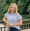 Headshot of Ryann Anderson, leaning against a bridge railing over a river.