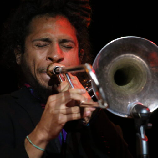 Close-up of a trombonist performing onstage.