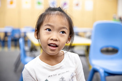 A younger Prekindergarten student with a happy expression.