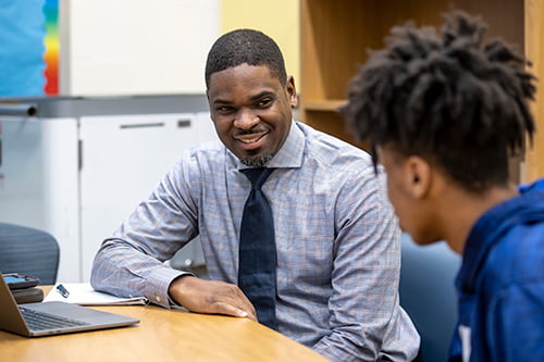 A male, African-American teacher speaking to students.