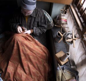 man working on textile