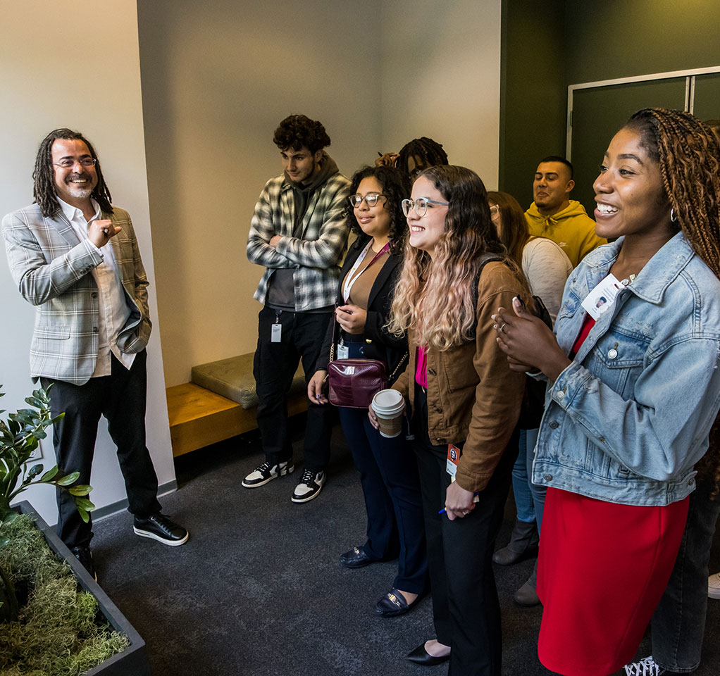 Man smiling as he stands with a group of students