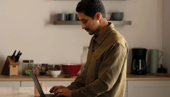 Man working on a laptop computer in his kitchen