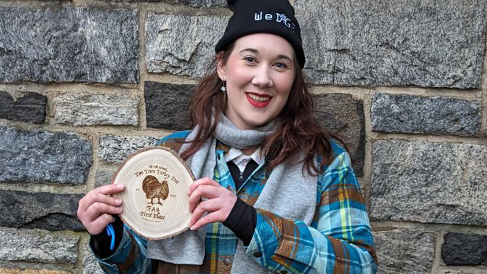 A woman holding a disc that is used for disc golf.