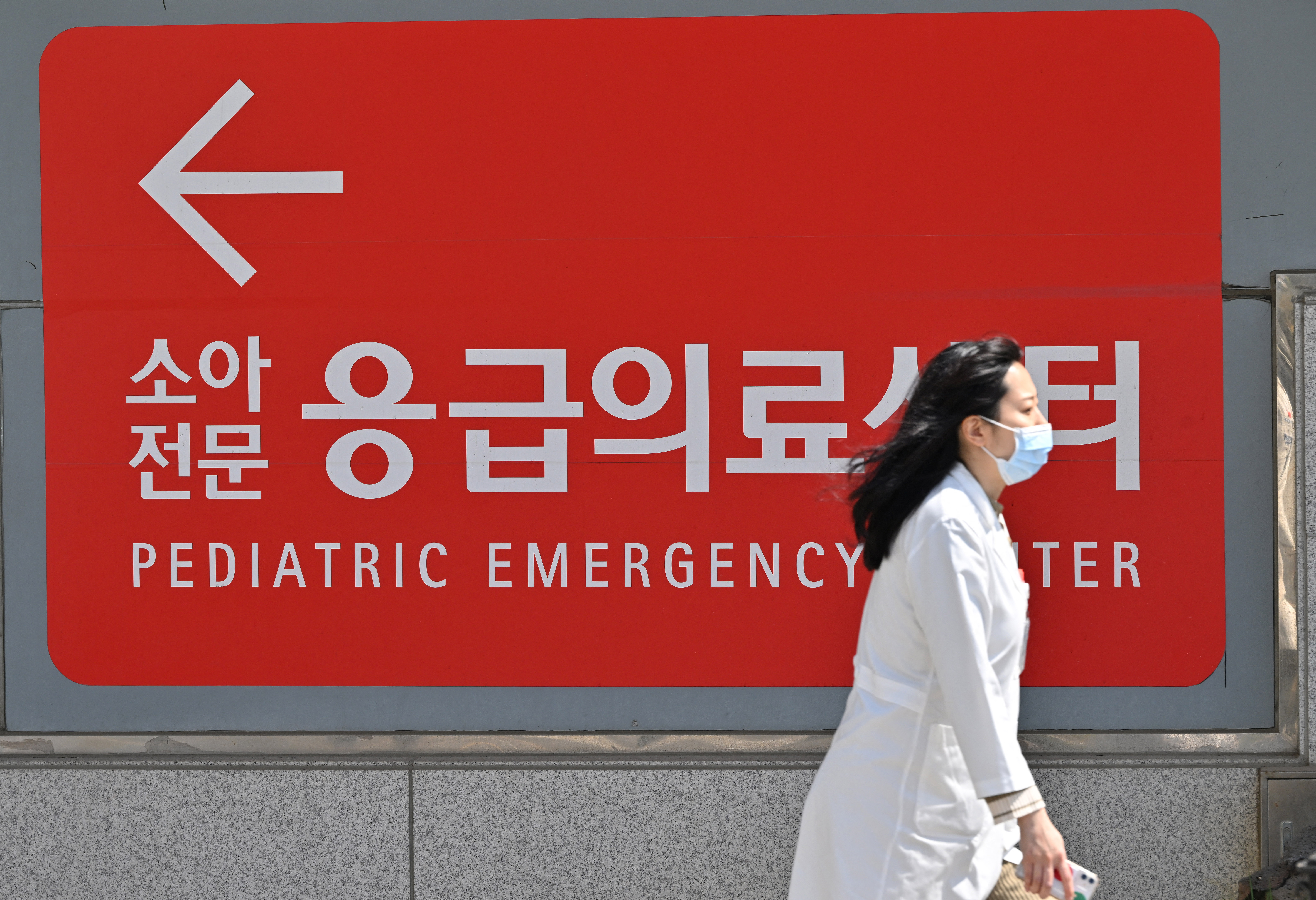 A medical worker walks past a sign for a pediatric emergency centre outside a hospital in Seoul on April 1, 2024.