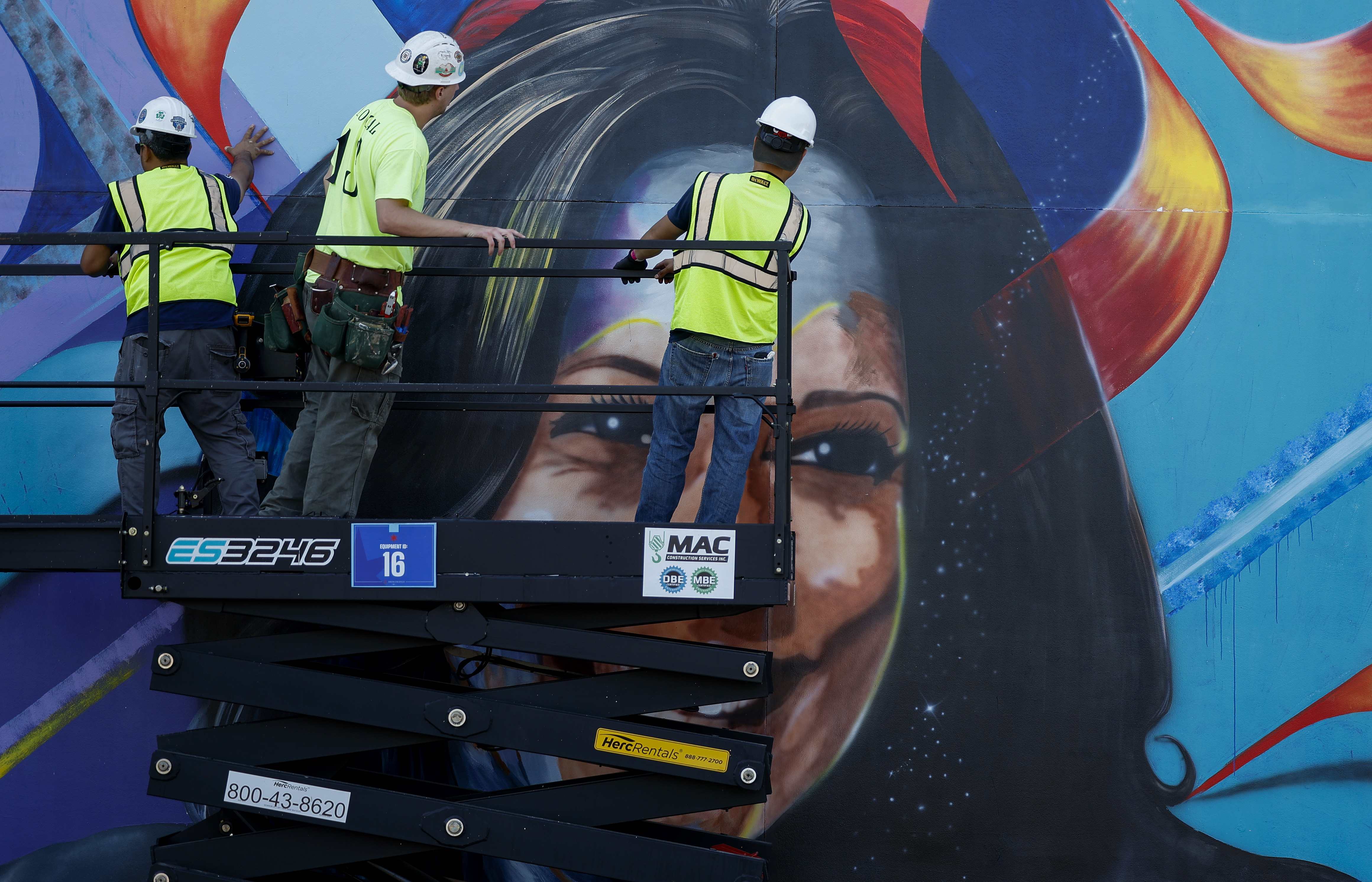 Ahead of the Democratic National Convention, workers construct a mural of Vice President Harris outside of Chicago's United Center in Chicago on Aug. 16, 2024.