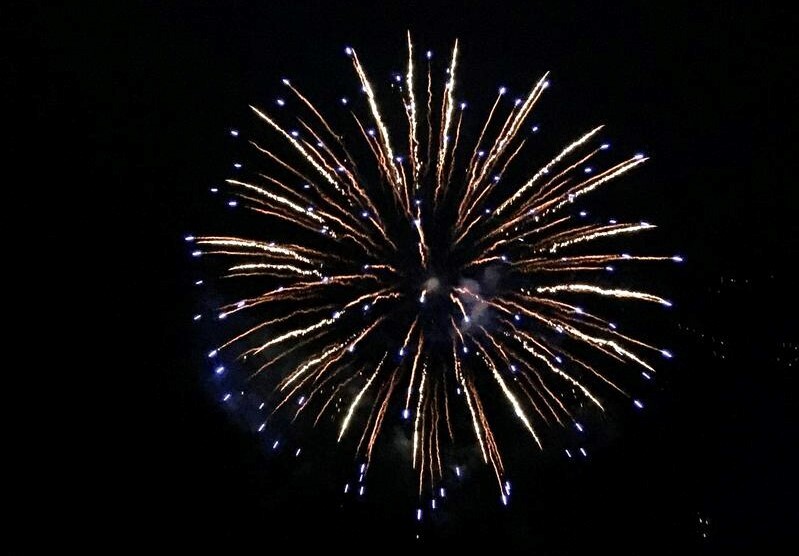 A firework explodes over a dark sky