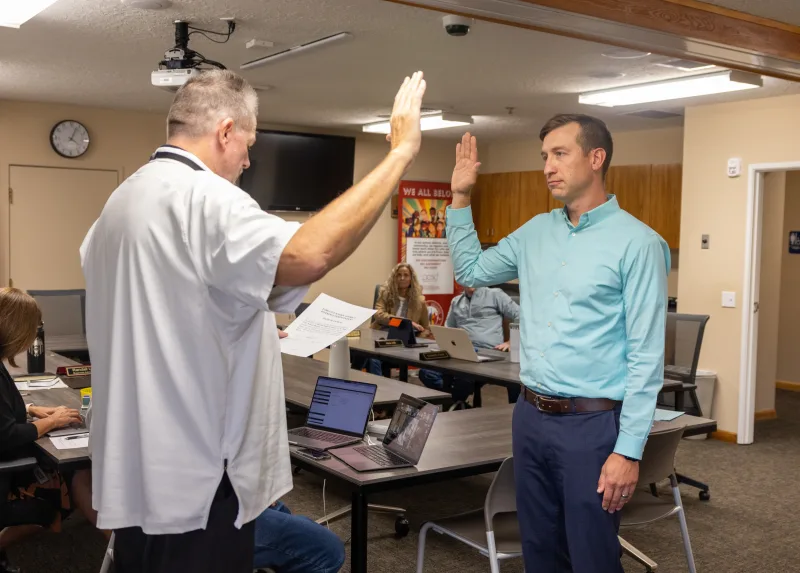 Park City School District Business Administrator Randy Upton (left) swears in Treasure Mountain Junior High School Principal Caleb Fine (right) as the district's interim superintendent Sept. 17, 2024. He replaces Superintendent Jill Gildea.