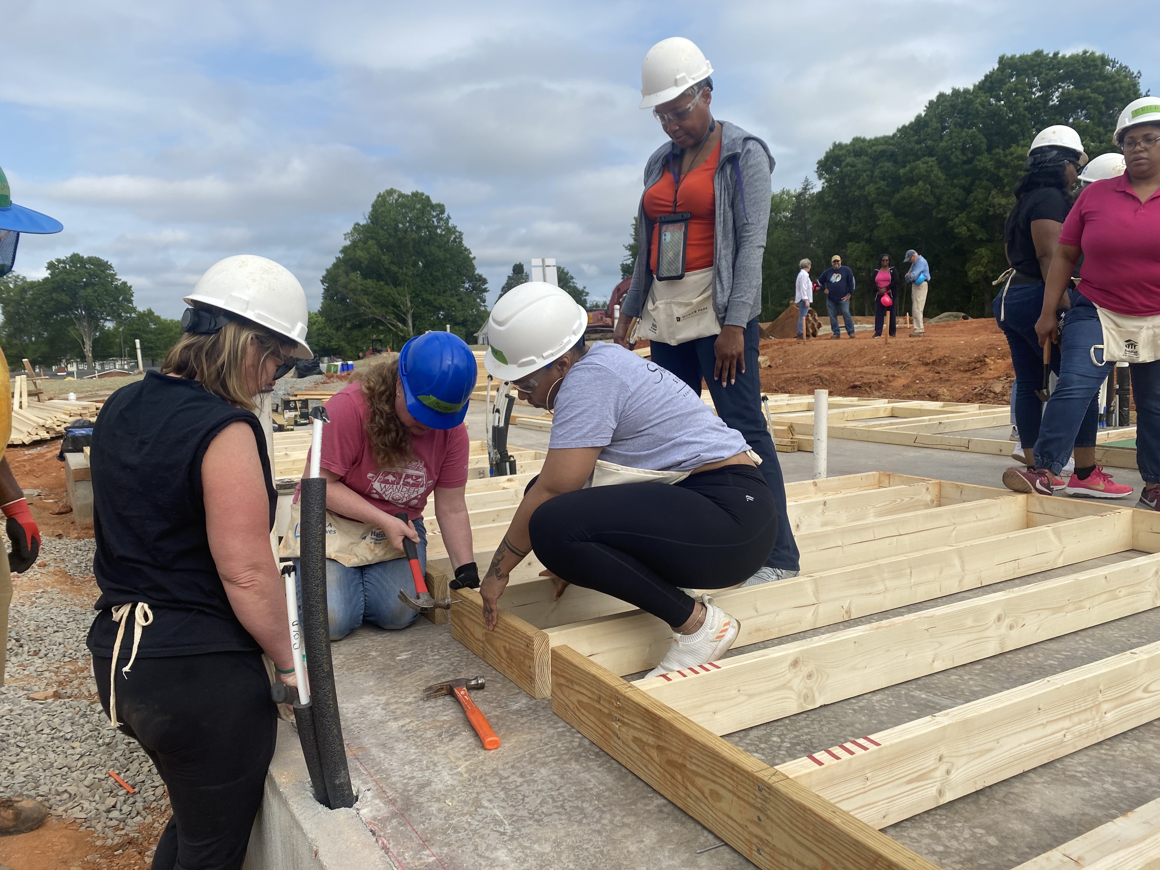 A group of women gather to help build the home.