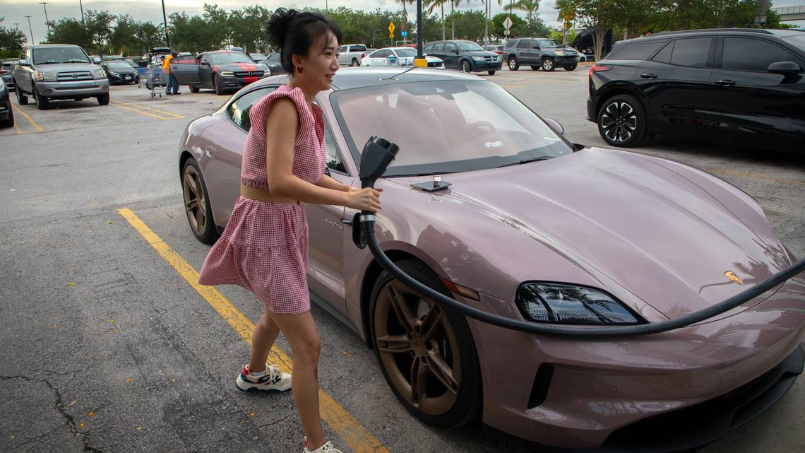 Tang P. plugs in her pink Porsche Taycan into an electric vehicle charging port in the Walmart parking lot in Hialeah on Friday, Sep. 24. Tang had two cars ahead of her in line waiting to use one of the five pumps.