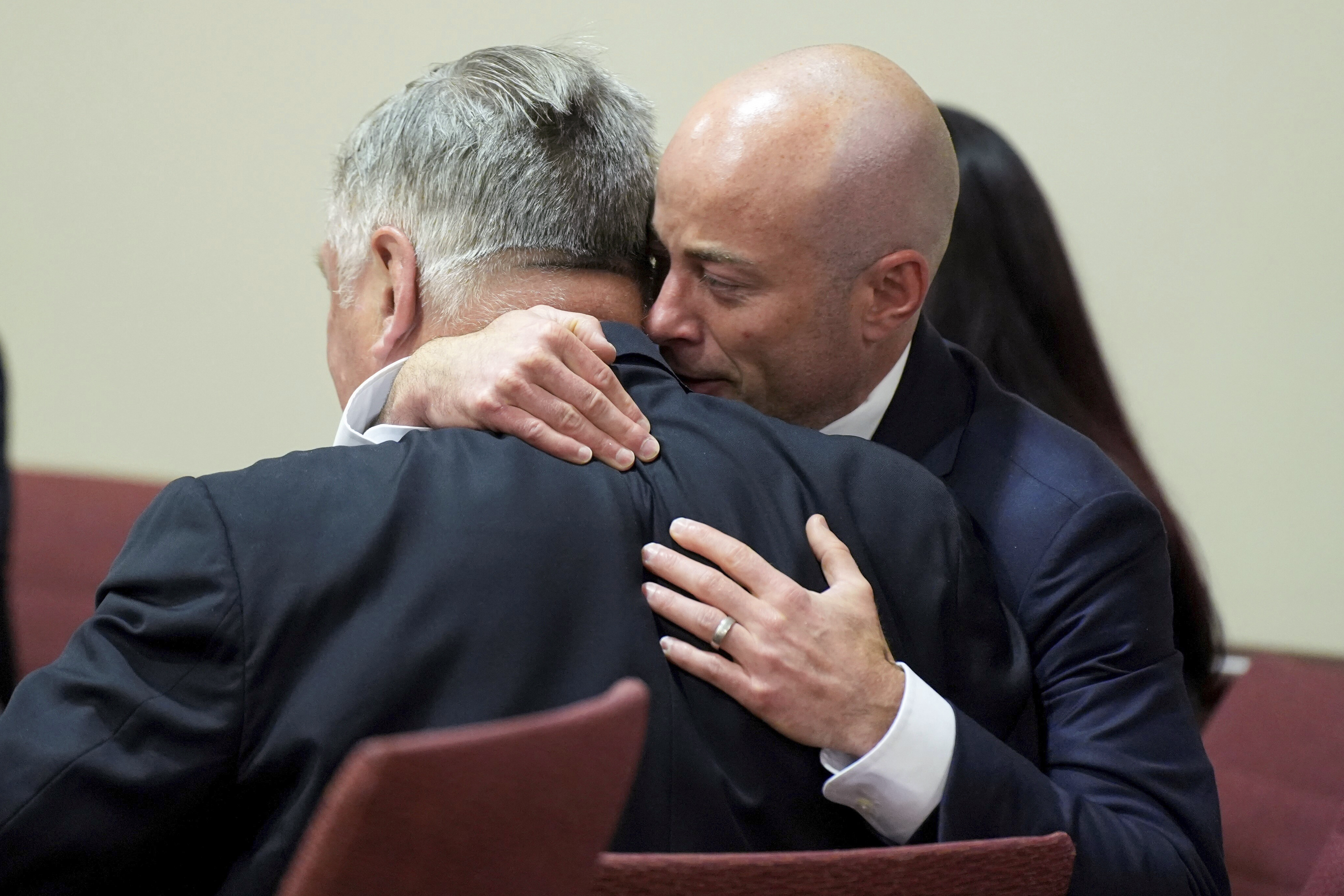 Attorney Luke Nikas, right, embraces actor Alec Baldwin.