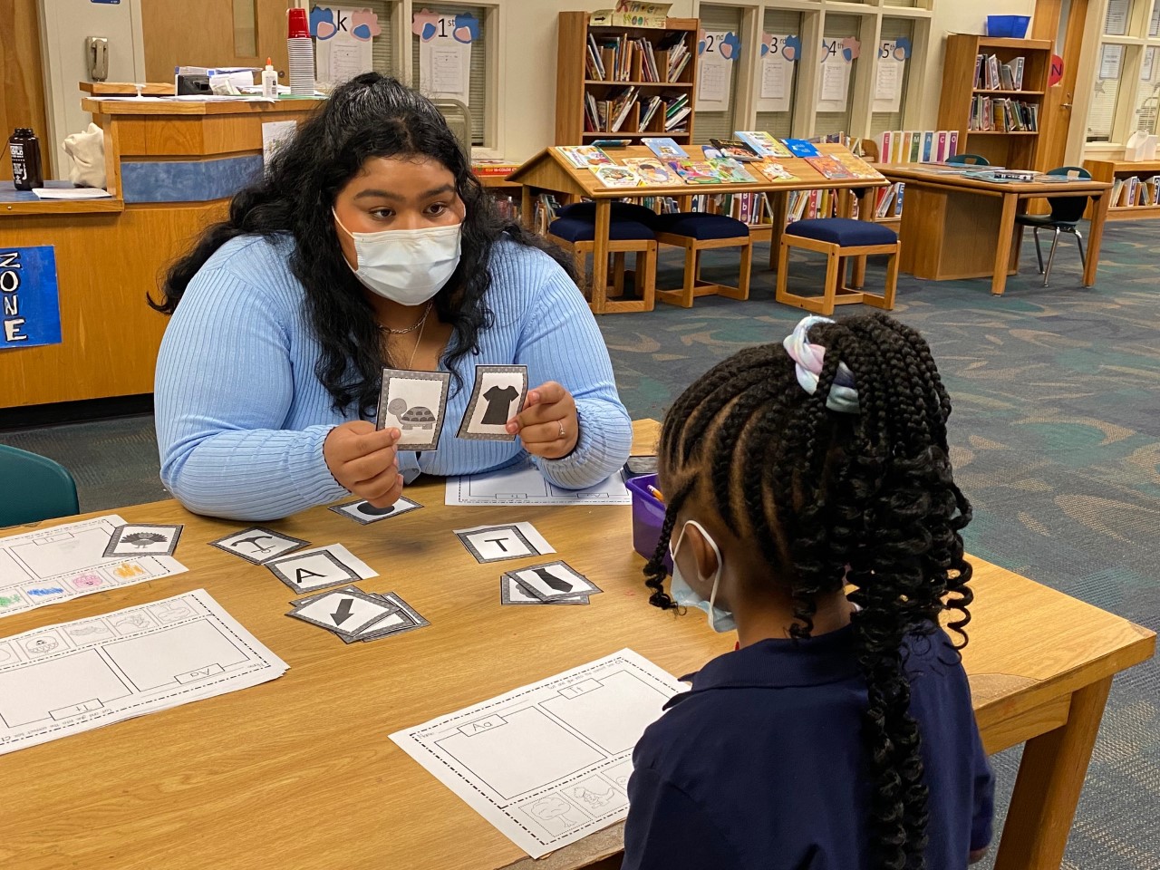 Landy Solorzano, a student at Charlotte Early Teacher College High School, works with a student at Hickory Grove Elementary School.