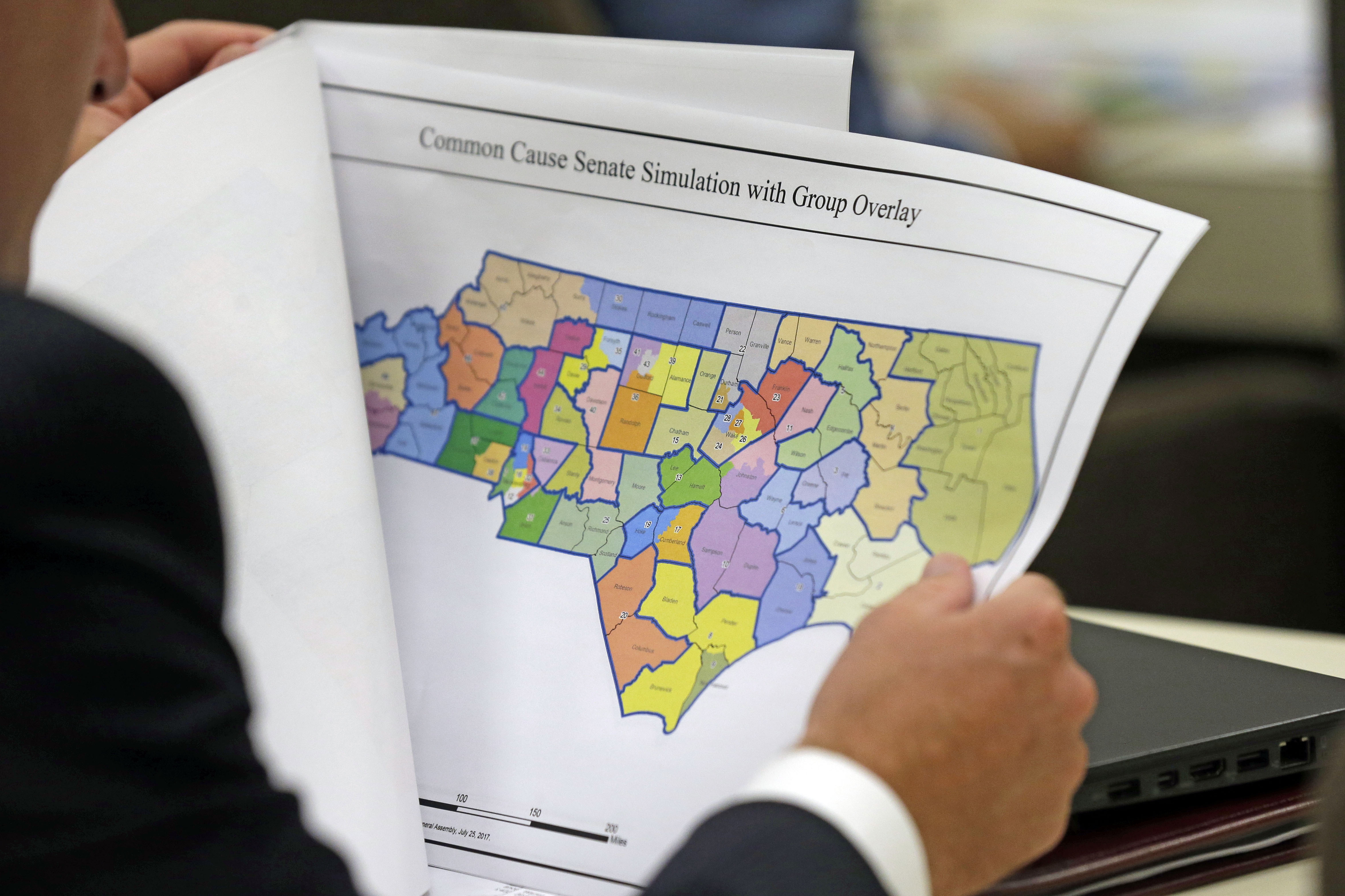 A North Carolina lawmaker studies a district map during a joint select committee meeting on redistricting, July 26, 2017, in Raleigh, N.C. North Carolina legislators are once again mapping the state’s congressional and General Assembly districts. The House and Senate redistricting committees scheduled hearings this week—the last one happening Wednesday, Sept. 27, 2023, in Raleigh—to receive public comment about the process of drawing district boundaries that would be used in the 2024 elections and for the remainder of the decade.