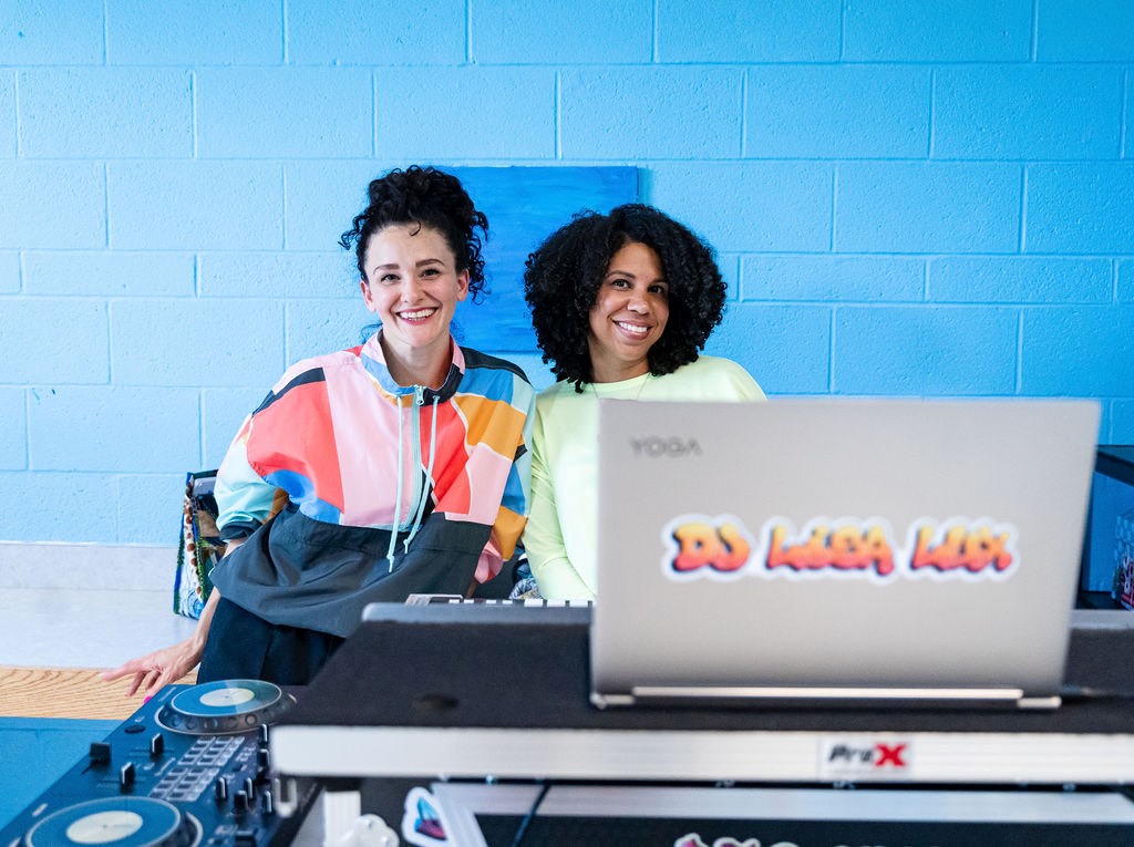 Breakdancer Stacy and DJ Lisa pose behind the turntables