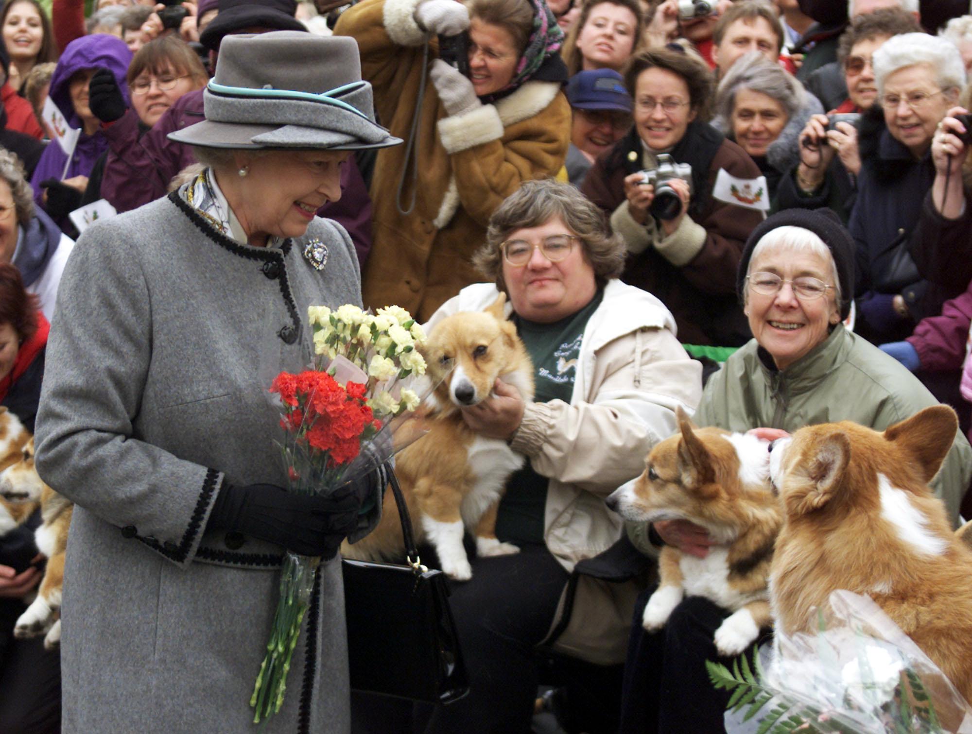 Queen Elizabeth II talks with members of the Manitoba Corgi Association during a visit to Winnipeg 08 October 2002.