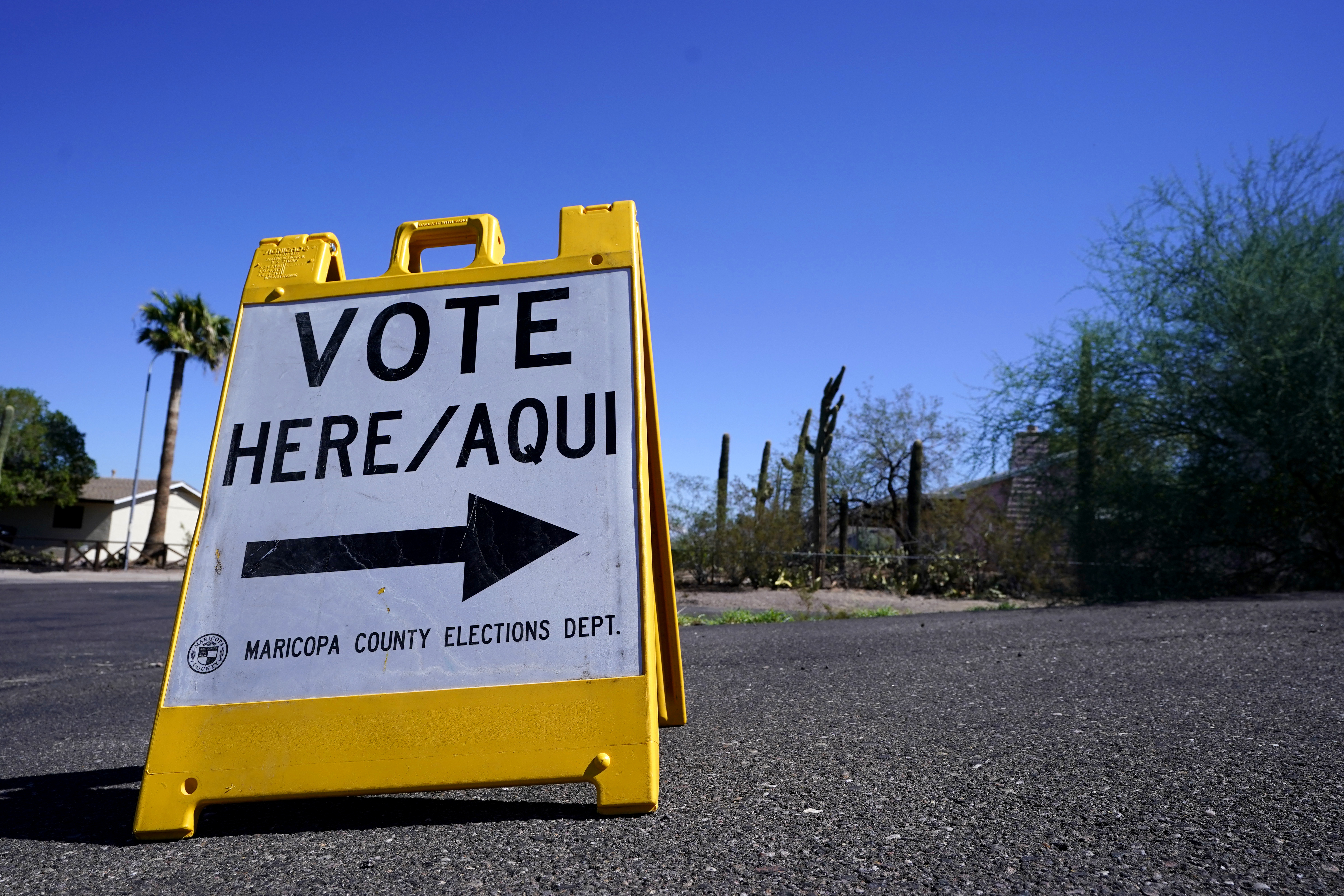 A sign marks the entrance to a voting precinct on the first day of early voting in the general election in Phoenix, Oct. 12, 2022. Arizona Latinos responded to a tough crackdown on immigrants by building a turnout machine that helped propel Democrats to power.