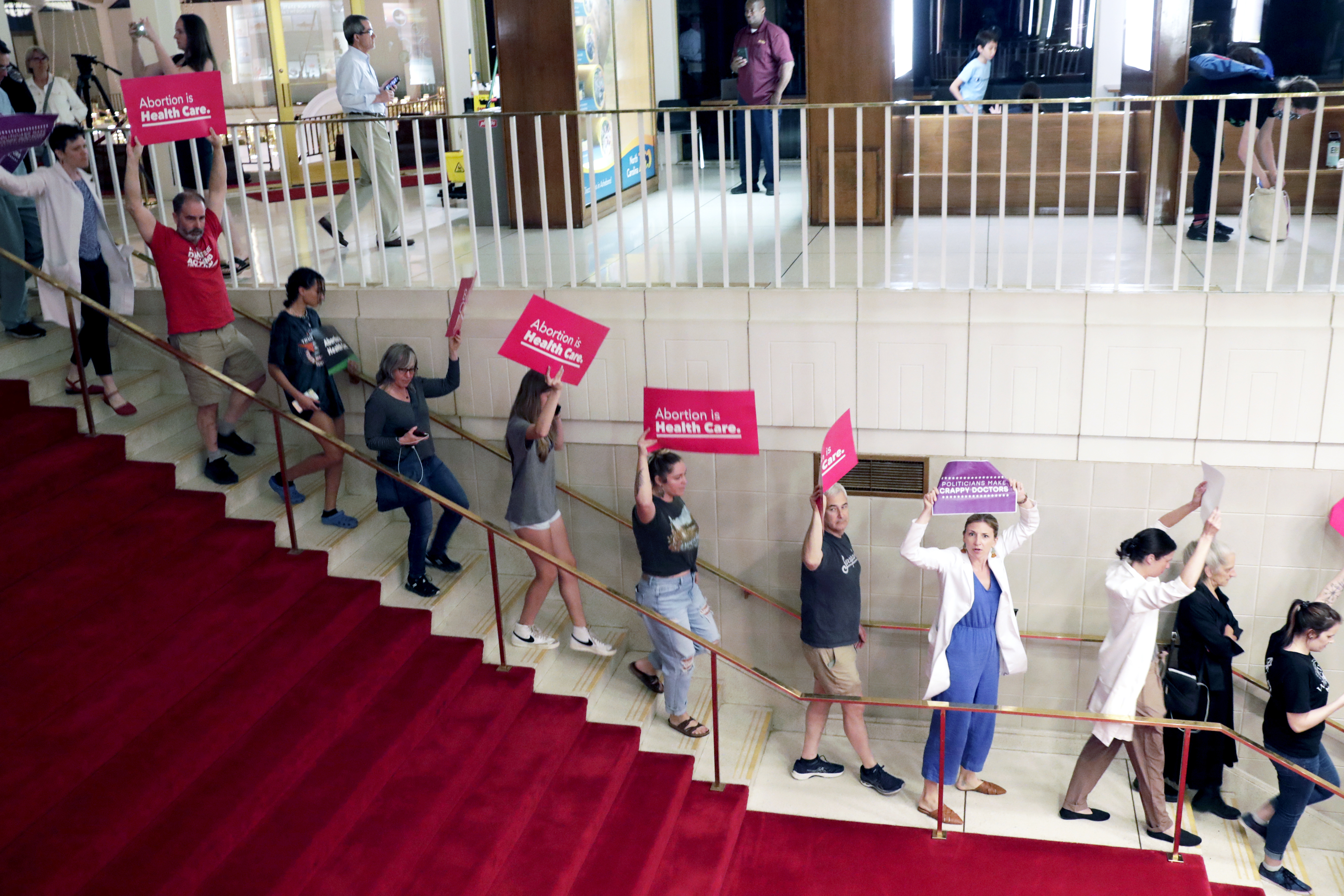 FILE - Abortion rights protesters go down the stairs