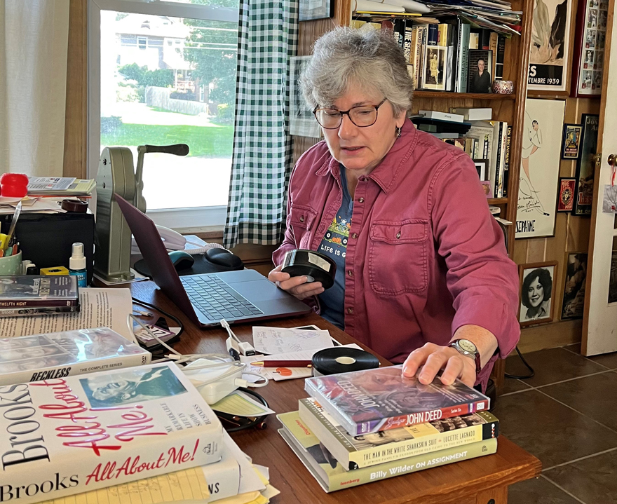 Audrey Kupferberg, seated at a desk in her office