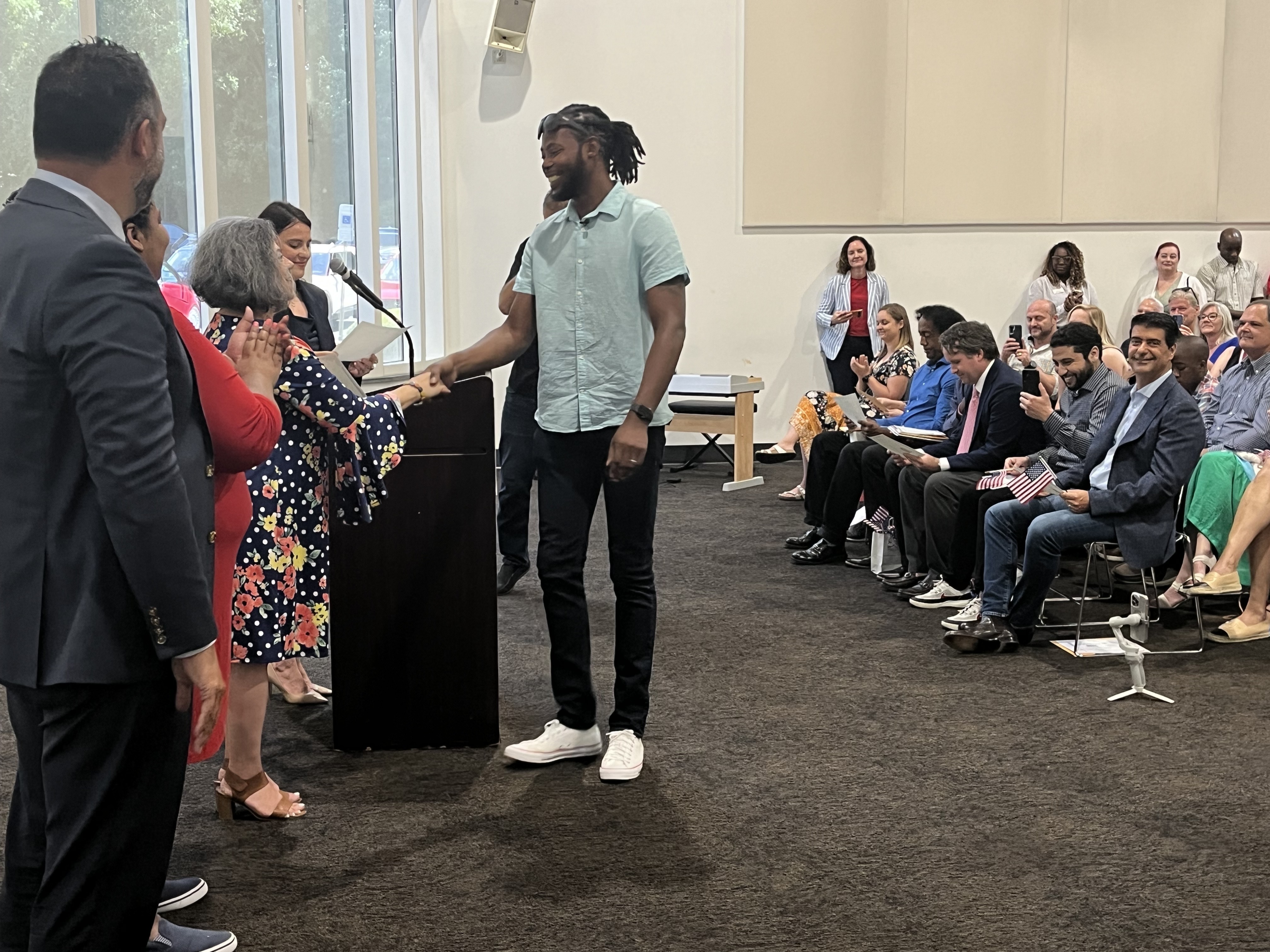 Davis Guzman receives his certificate as he became one of 17 new U.S citizens recognized at a naturalization ceremony at the Charlotte Museum of History.