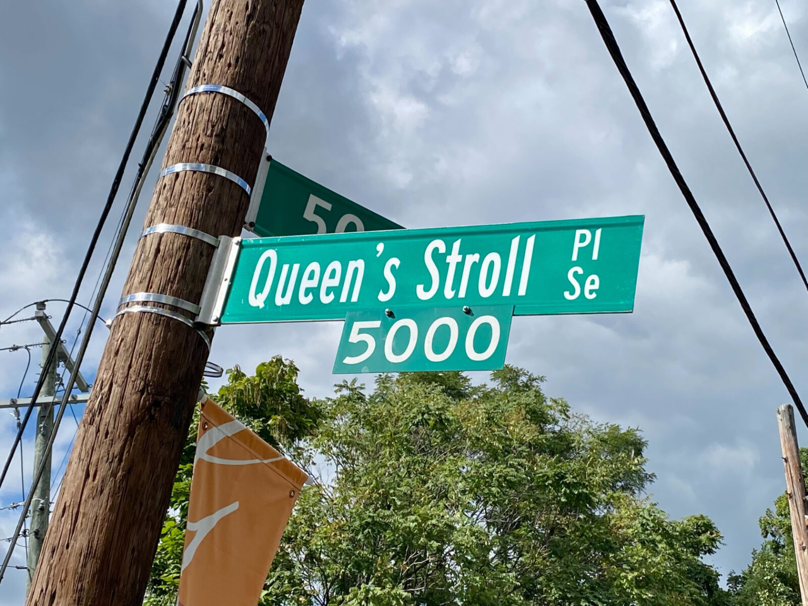 A D.C. street sign reads "Queen's Stroll Pl. SE" 
