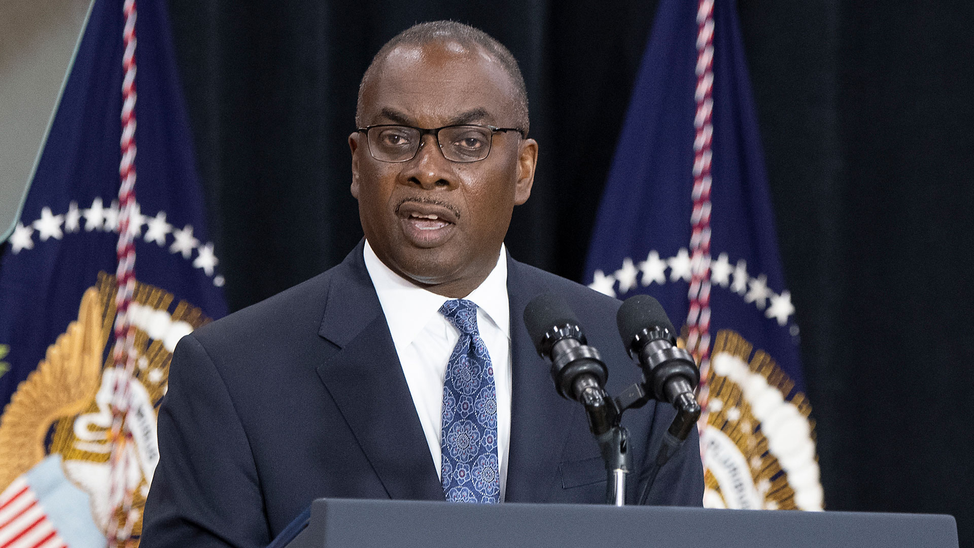 Buffalo Mayor Byron Brown, wearing a blue suite, white shirt and blue tie, speaks at two microphones.