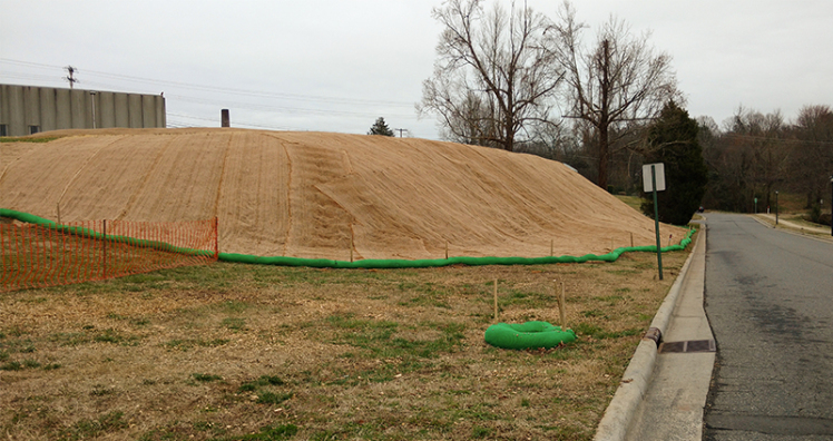 Workers cut down trees and shrubs then installed a plastic liner, soil and a fiber mat cover on this slope near the former Carolina Asbestos plant in Davidson. Last fall, environmental officials found asbestos running off from the hill. 