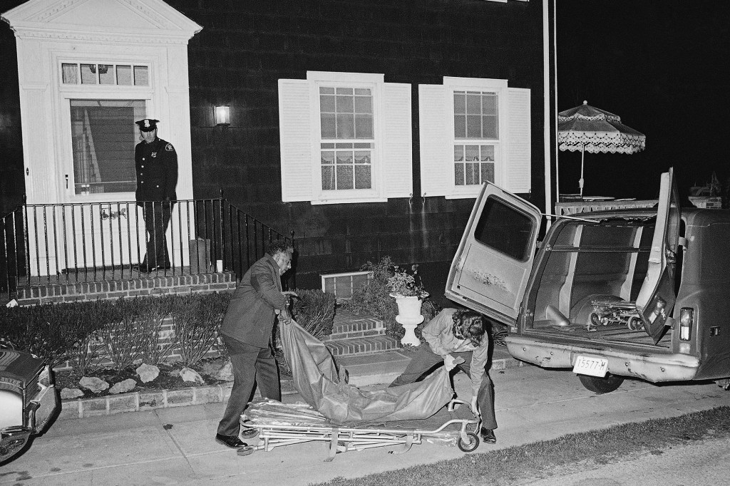 Two members of the Suffolk County Coroner's Office remove one of six bodies that were found shot in Amityville on Nov. 14, 1974.