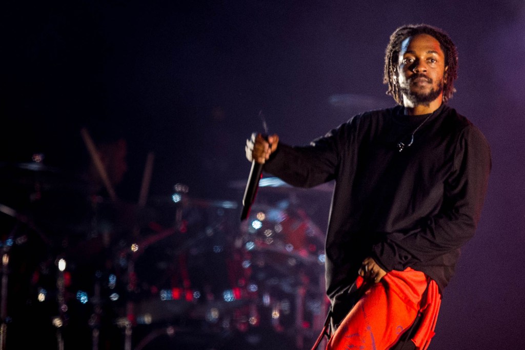 Kendrick Lamar holds a microphone onstage