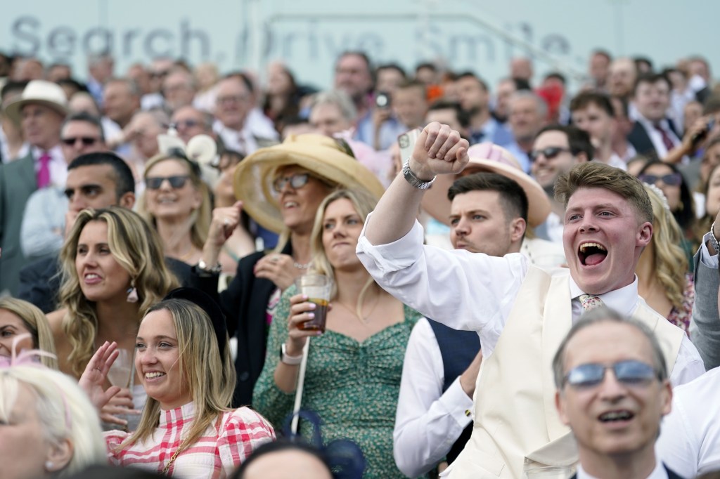 Racegoers in the stands react to the Cazoo Handicap on Ladies Day during the Cazoo Derby Festival 2022 at Epsom Racecourse, Surrey on June 3, 2022.