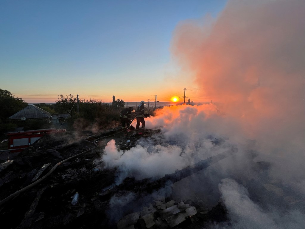 Ukrainian firefighters put out fire in a residential house after a Russian military strike in the Donetsk region on Monday. 